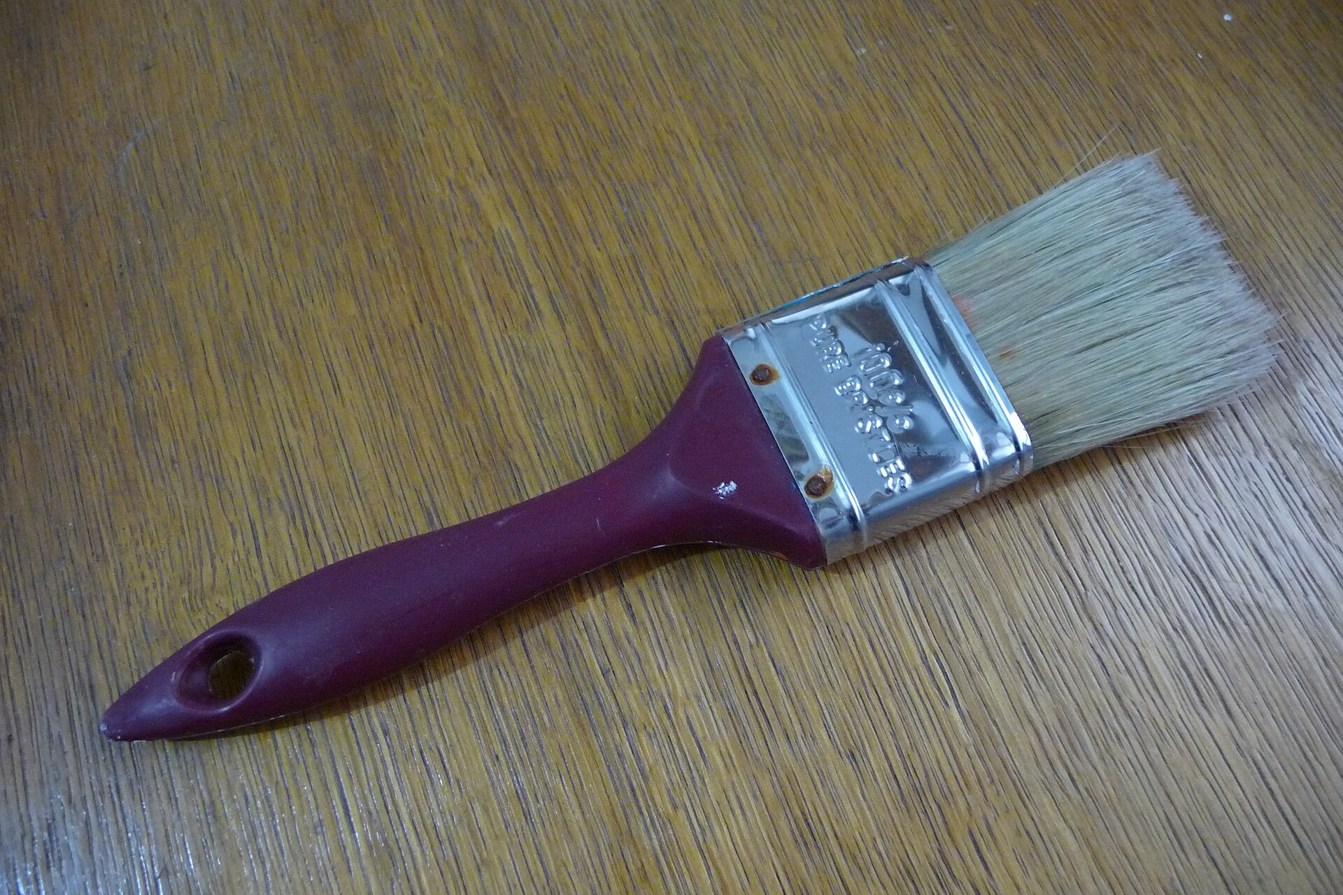 A paint brush lying on a wooden table
